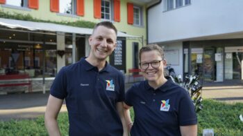 Zwei Menschen lächeln in die Kamera